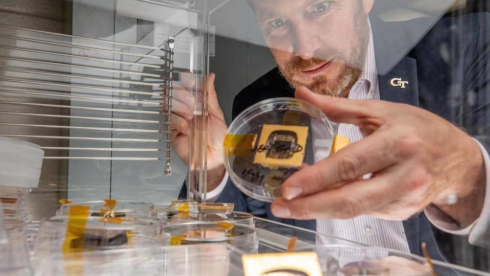 Jud Ready holds a sample of a perovskite solar cell, along with other samples similar to those launched to the International Space Station. (Photo: Branden Camp)